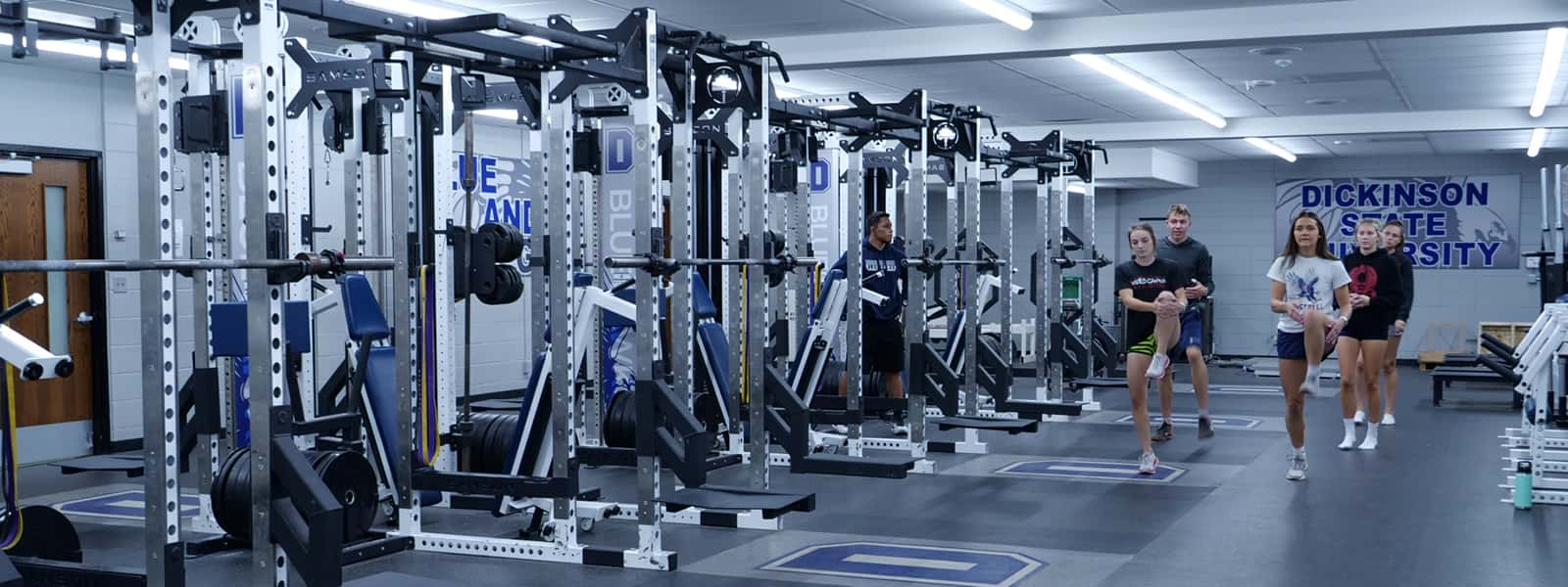 Students in a facility containing various exercise equipment.