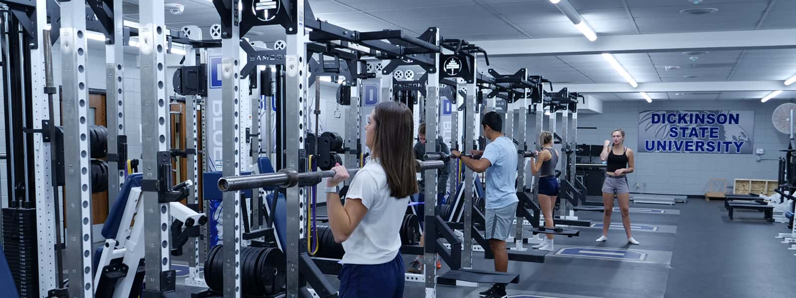 Students in a facility containing various exercise equipment. 