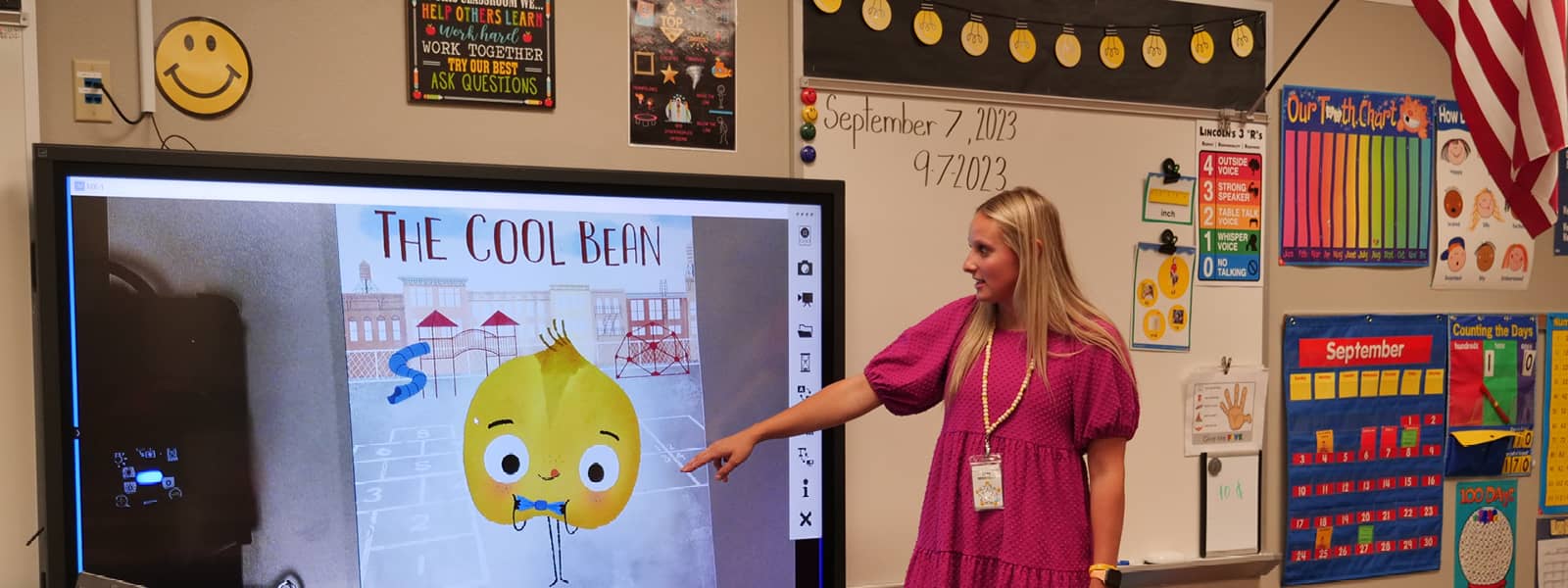 A woman giving a presentation in an elementary school classroom. 