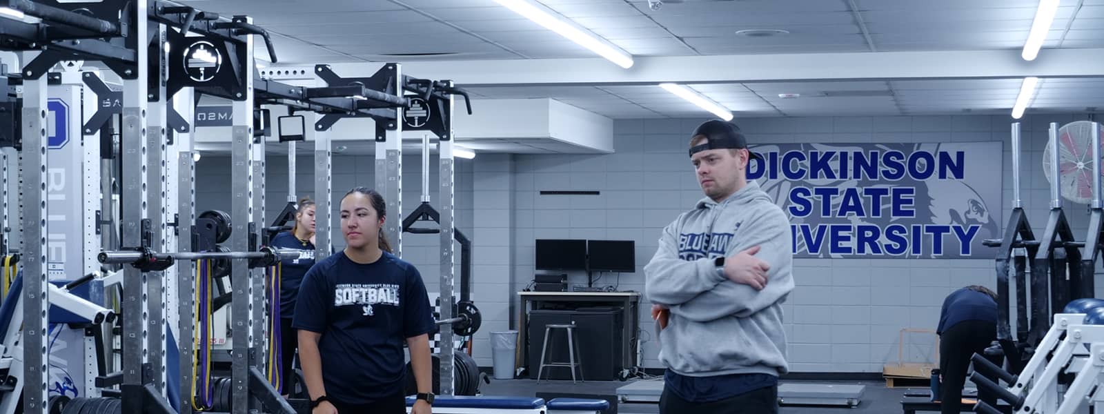 Students in a facility containing various exercise equipment. 